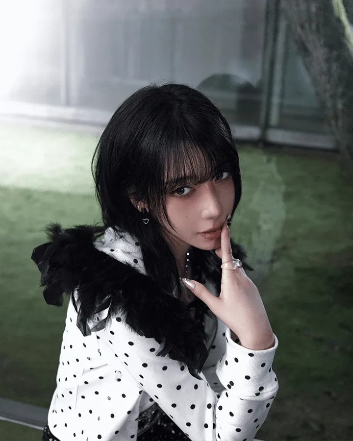 Kat of A2O MAY in a polka-dot jacket with a feathered collar, in her official profile portrait