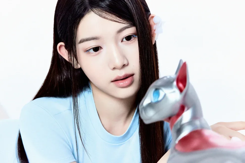 Merci of A2O LITE with long dark hair beside a silver robotic cat, in her official NEON artwork