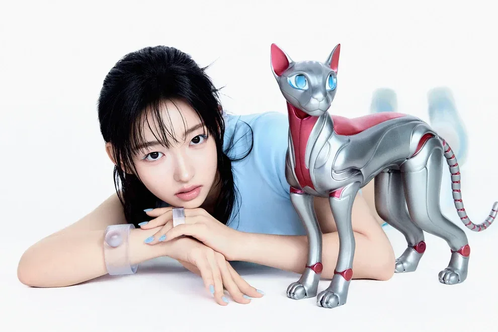 Vora of A2O LITE leaning on her arms next to a silver robotic cat, in her official NEON artwork