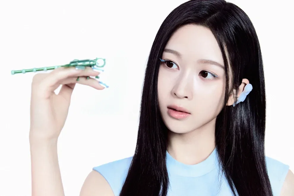 Young of A2O LITE in a light blue top holding a small robotic insect, in her official NEON artwork
